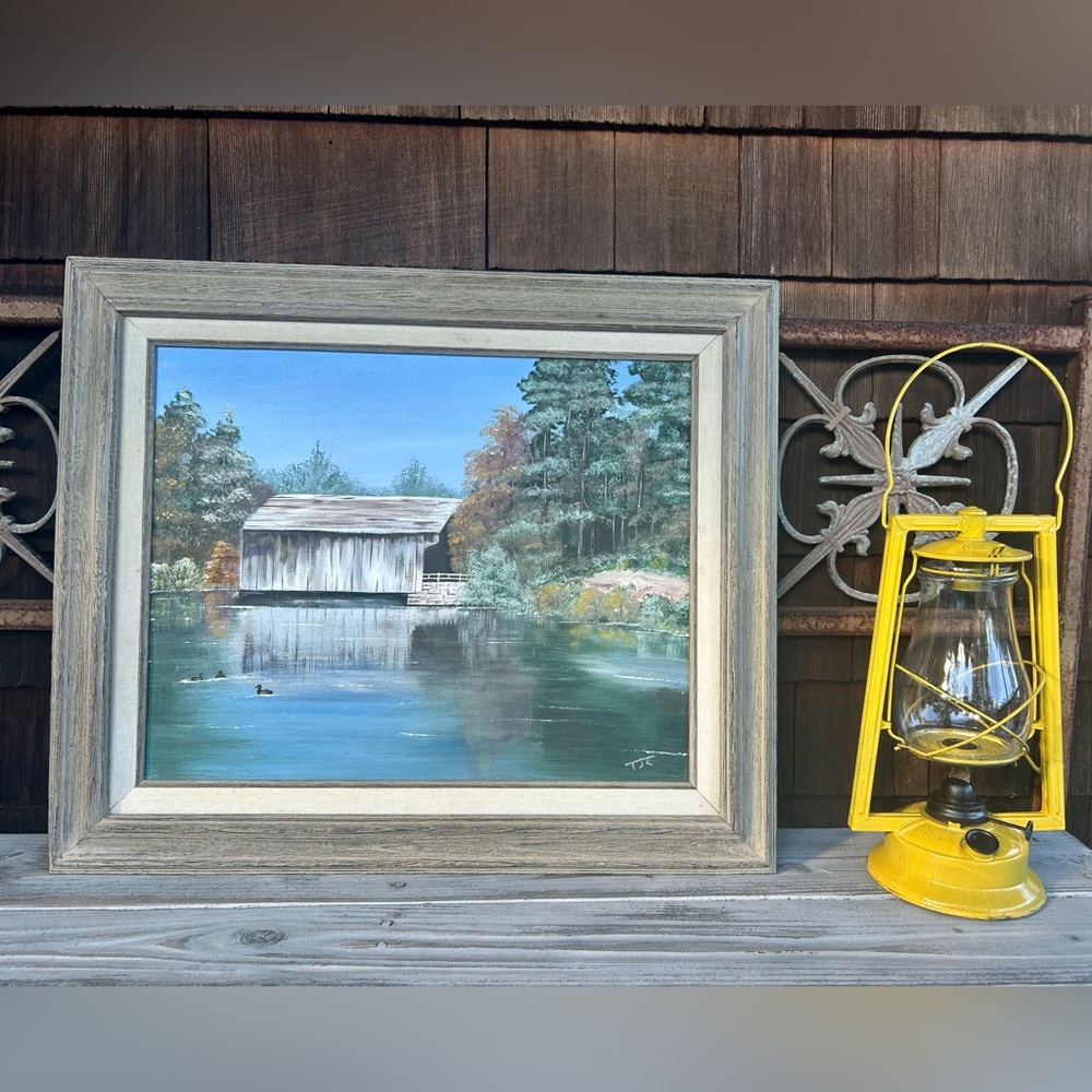 Rustic Framed Landscape Painting of a Covered Bridge by the Water.